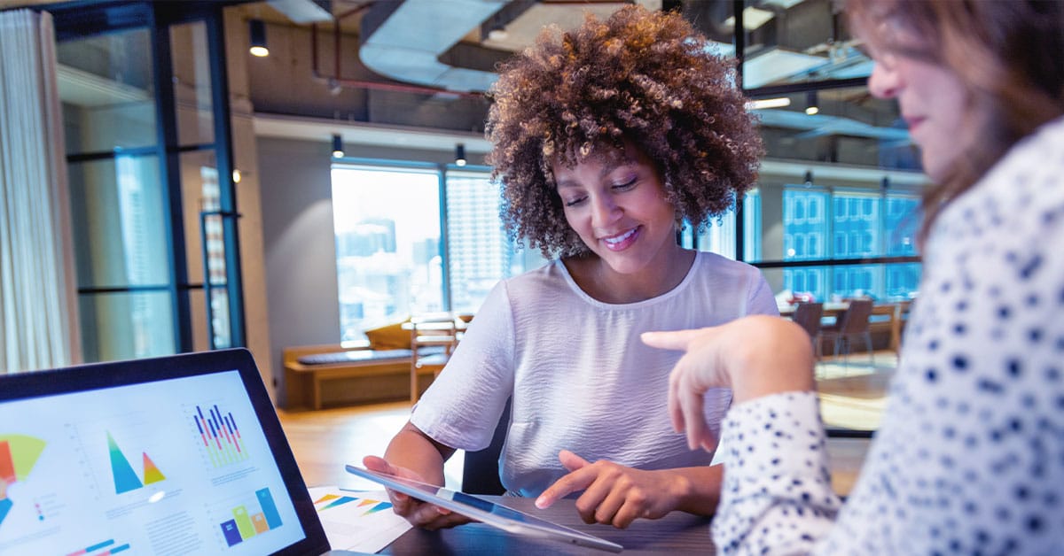 a person sitting at a table in front of a laptop